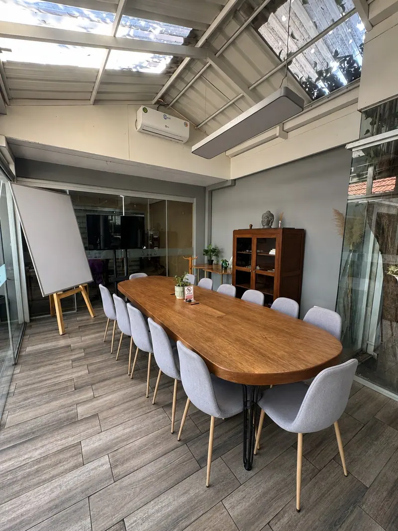 Sala de reuniones con mesa oval bajo techo vidriado