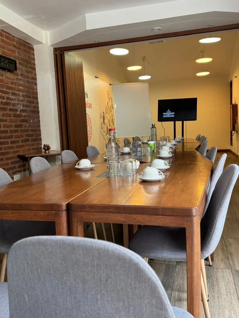 Sala con muro de piedra y mesa servida con tazas